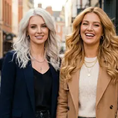 Dwie kobiety, jedna z platynowym blondem, druga ze złotym blondem, uśmiechają się na ulicy.
