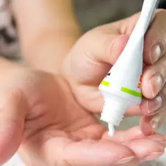 Dłoń wyciska maść z arniki na twarz. Delikatna pielęgnacja dla Twojej skóry.
