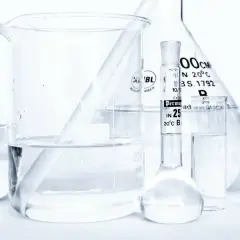 Laboratorium z kolbami i zlewkami, w których znajduje się płyn, być może butylene glycol, gotowy do analizy.