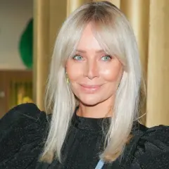 Uśmiechnięta kobieta z jasnymi włosami i lekka grzywka na boki.