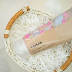 Balsam do ciała Resibo w koszyku z ozdobnym wypełnieniem. Składnik sodium coco sulfate zapewnia delikatne oczyszczanie.