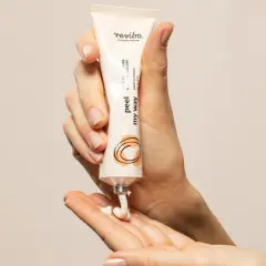 Dłonie aplikują peeling do twarzy Resibo. Delikatna eksfoliacja dla promiennej cery.