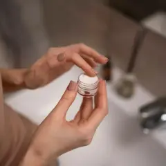 Dłonie nabierają krem z małego słoiczka. Zastanawiasz się retinol co to? To składnik, który odmieni Twoją skórę.