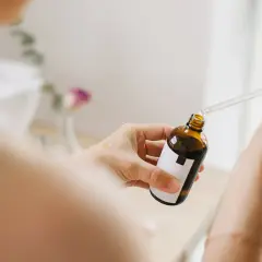 Kobieta aplikuje serum z pipetką na dłoń. Bezpieczny niacynamid w ciąży to dobry wybór dla delikatnej skóry.