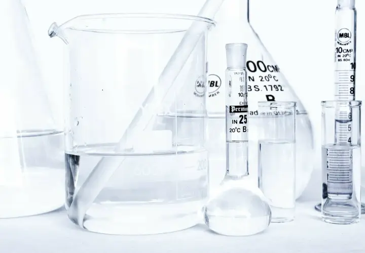 Laboratorium z kolbami i zlewkami, w których znajduje się płyn, być może butylene glycol, gotowy do analizy.