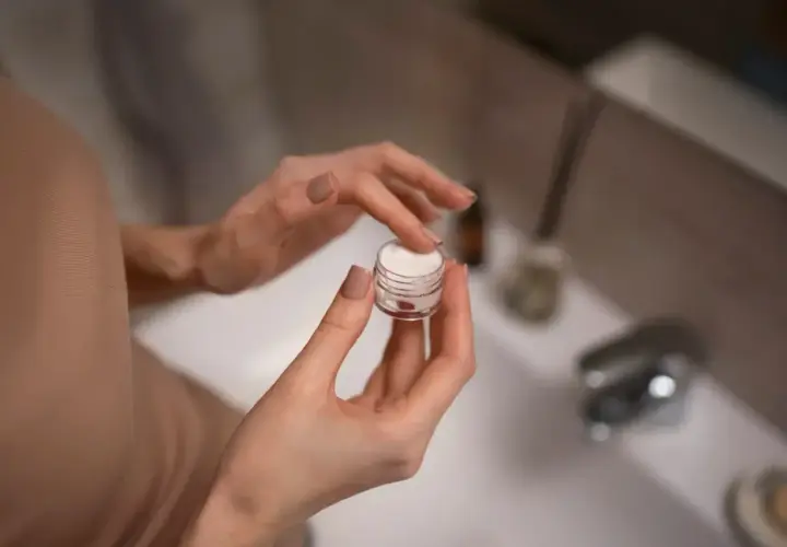 Dłonie nabierają krem z małego słoiczka. Zastanawiasz się retinol co to? To składnik, który odmieni Twoją skórę.