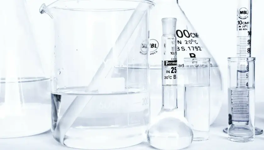 Laboratorium z kolbami i zlewkami, w których znajduje się płyn, być może butylene glycol, gotowy do analizy.
