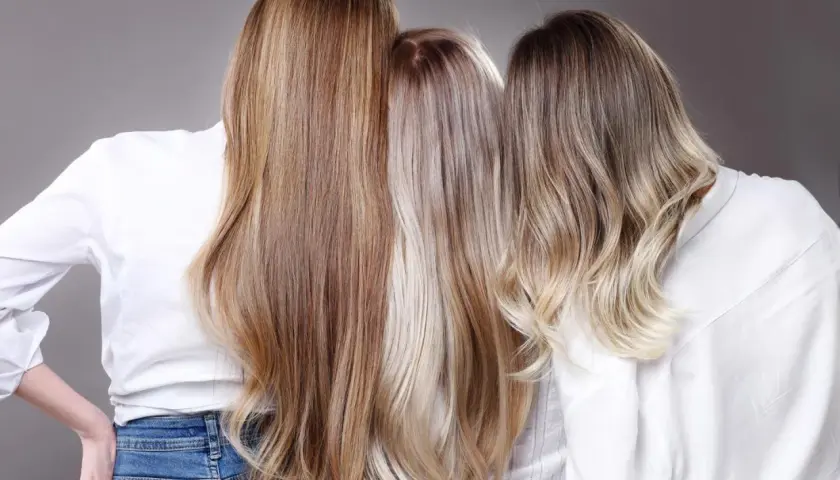 Trzy kobiety prezentują różne odcienie sombre blond, od ciepłych brązów po chłodne platynowe refleksy.