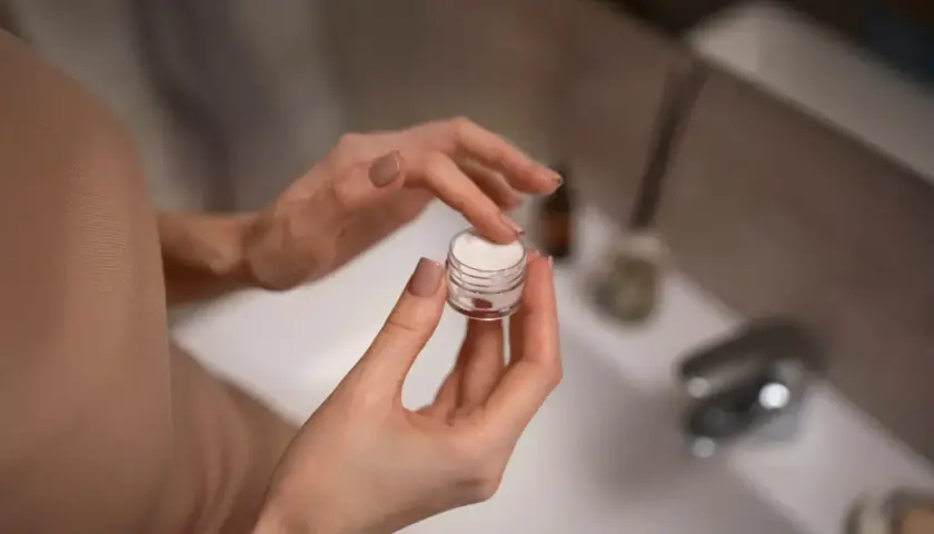 Dłonie nabierają krem z małego słoiczka. Zastanawiasz się retinol co to? To składnik, który odmieni Twoją skórę.
