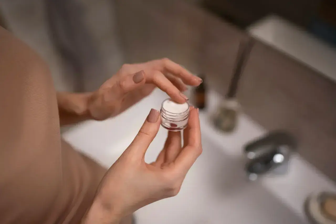 Dłonie nabierają krem z małego słoiczka. Zastanawiasz się retinol co to? To składnik, który odmieni Twoją skórę.