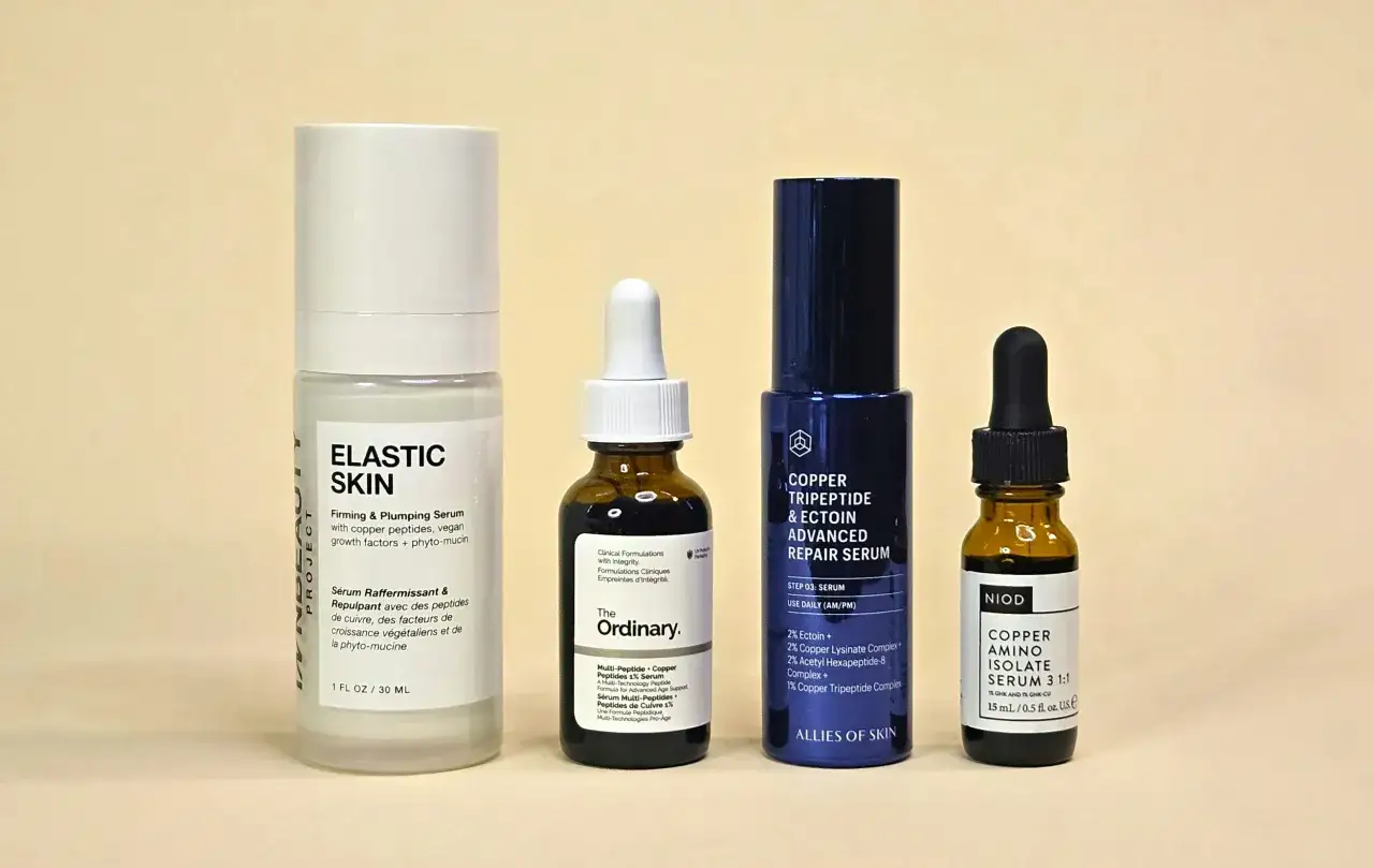 Cztery serum do twarzy, w tym jedno z peptydem miedziowym, na jasnym tle.