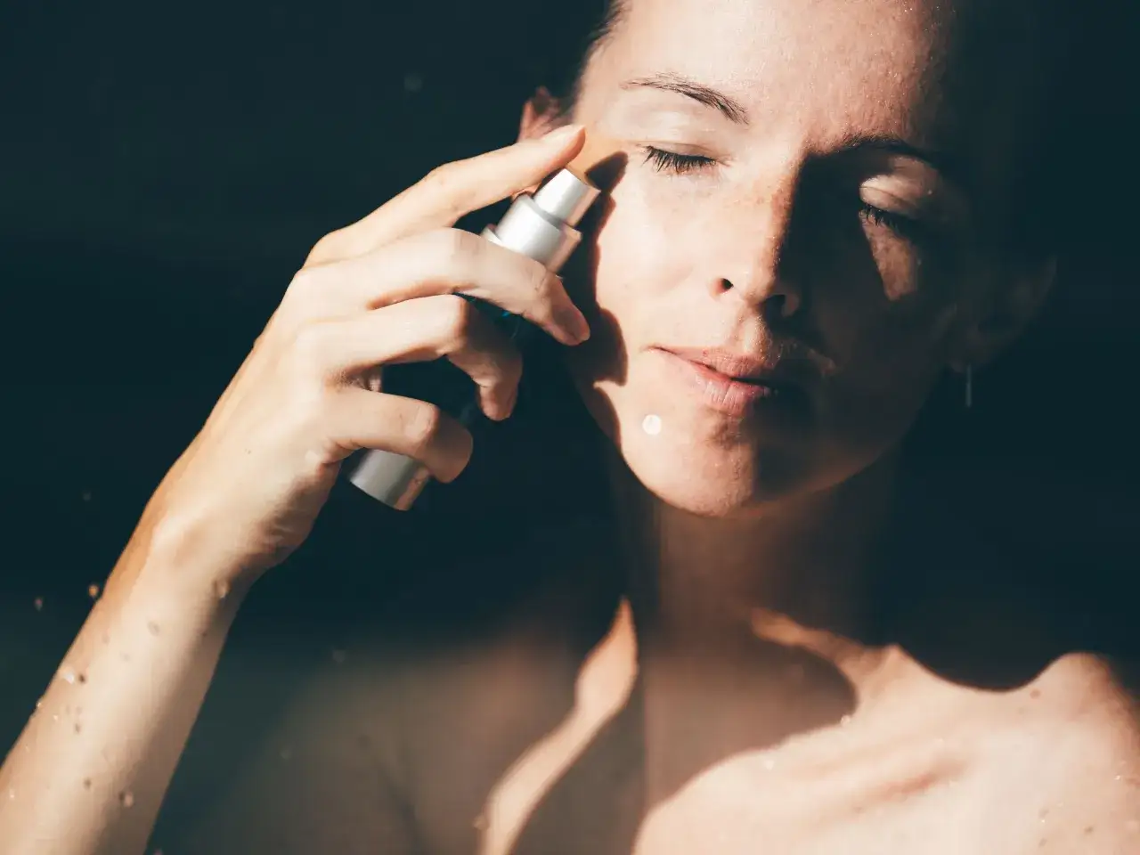 Kobieta aplikuje kosmetyk na twarz. Czy to jest retinol? Ten składnik aktywny może pomóc w odmłodzeniu skóry.