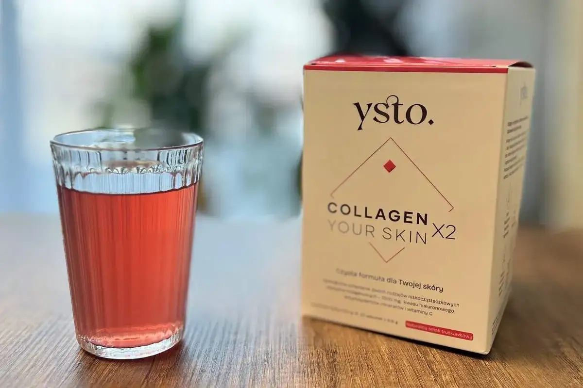 Szklanka z napojem obok pudełka z peptydami kolagenowymi YstO. Collagen Your Skin X2 o smaku truskawkowym.