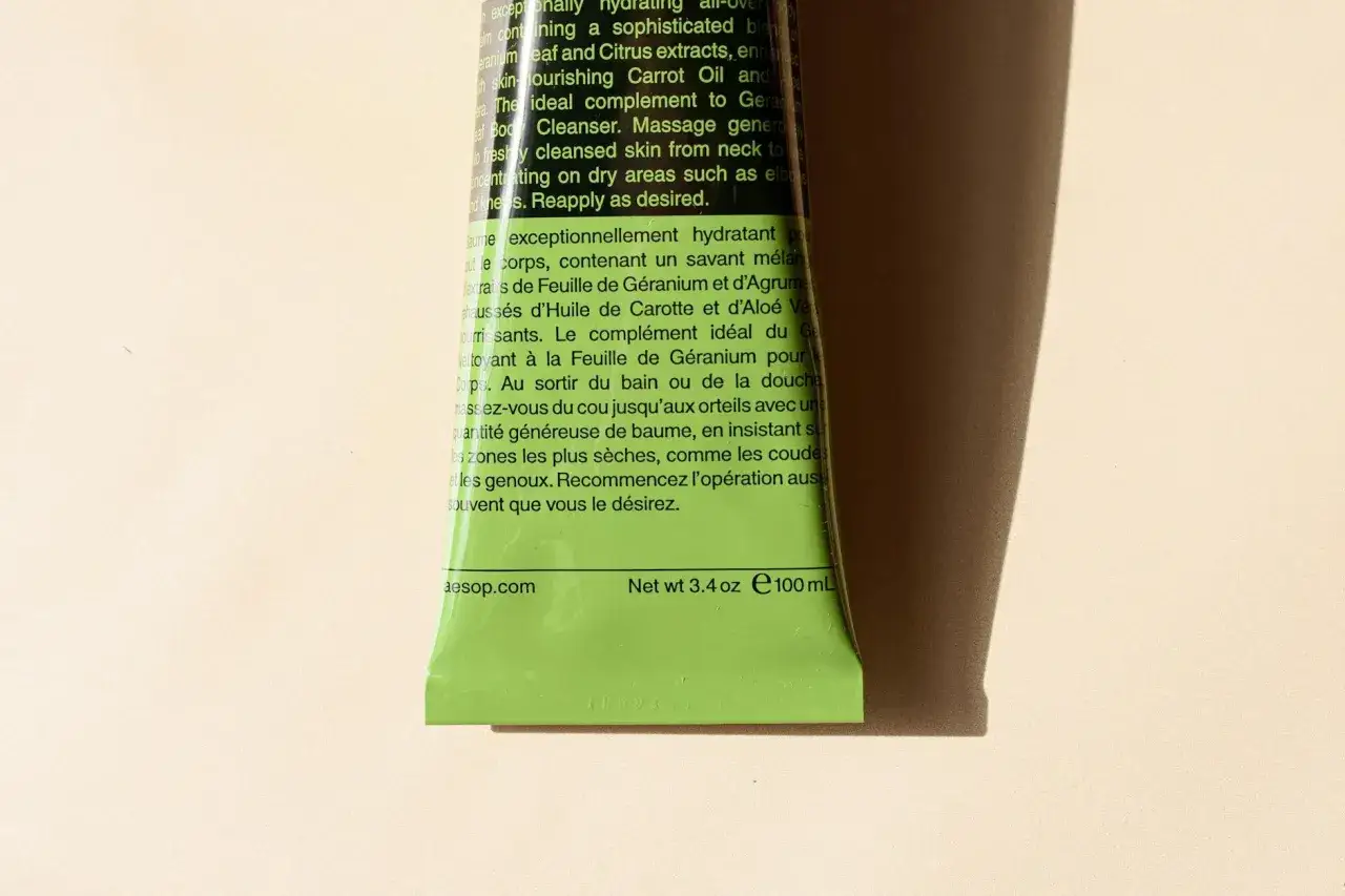 Zielony tubka z balsamem do ciała Aesop, zawierająca ekstrakt z geranium. Idealny do nawilżania skóry.